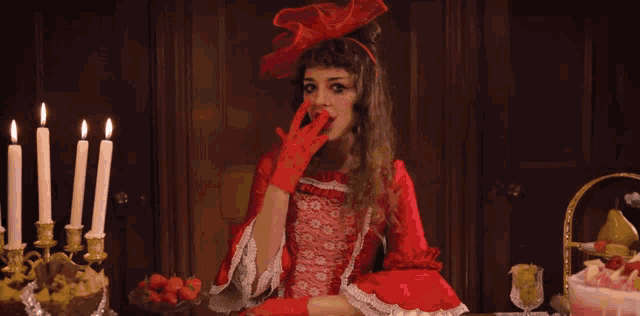 a woman in a red dress holds a red object