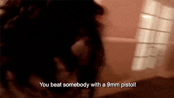 a person is holding a gun in a room and says `` you beat somebody with a 9mm pistol '' .