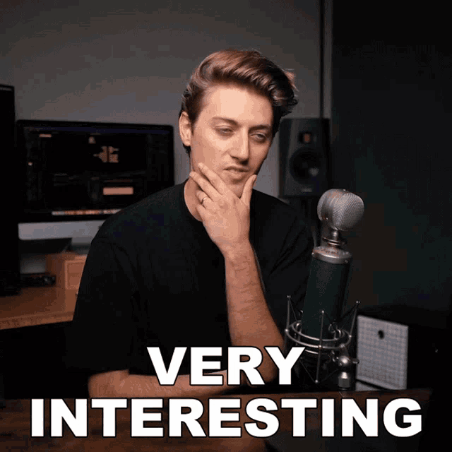 a man sitting in front of a microphone with the words " very interesting " below him