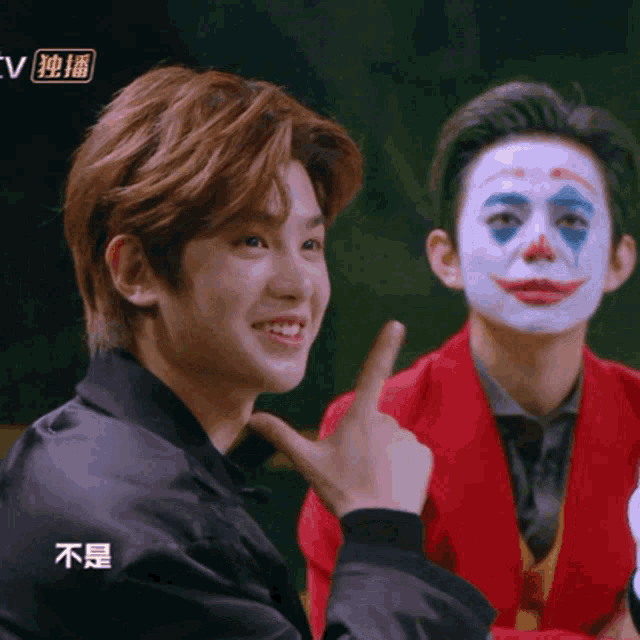 a man in a clown costume points to another man