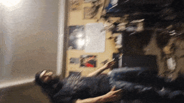 a blurry picture of a man laying on his back with a poster on the wall that says ' apocalypse '
