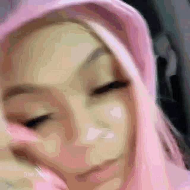 a close up of a woman wearing a pink hat