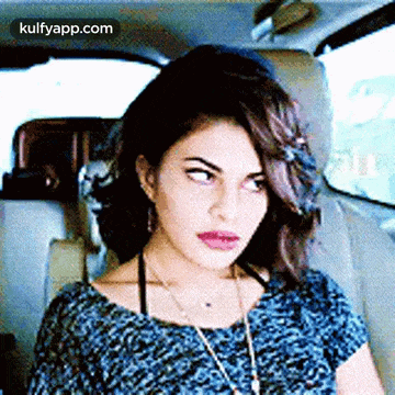 a woman is sitting in the back seat of a car