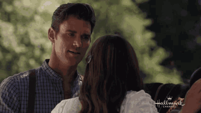 a man and a woman are looking at each other in a hallmark channel advertisement