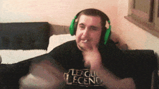 a man wearing headphones and a league legend shirt is sitting on a couch