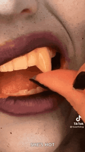 a close up of a person 's mouth with fake teeth and purple lipstick .