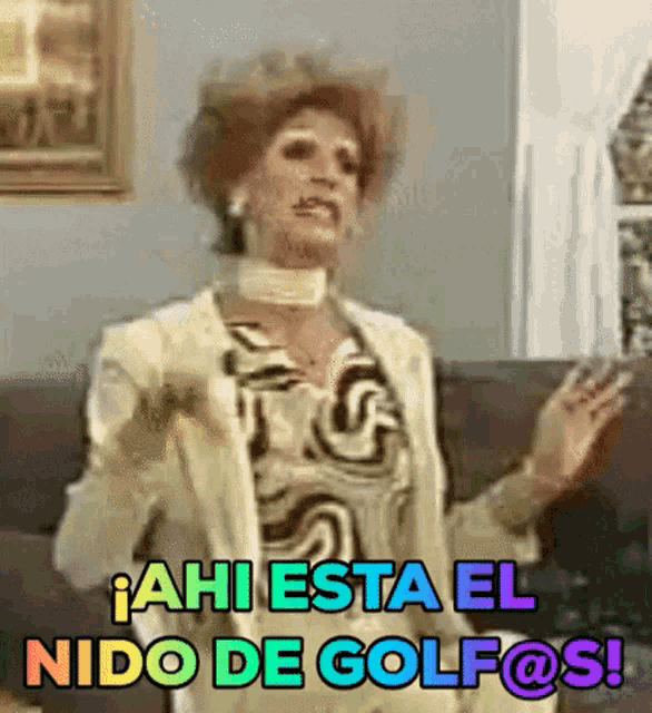 a woman is sitting on a couch and says " ahi esta el nido de golfos "