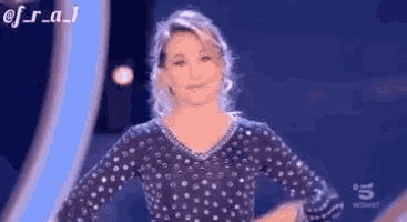 a woman is standing on a stage wearing a polka dot dress .