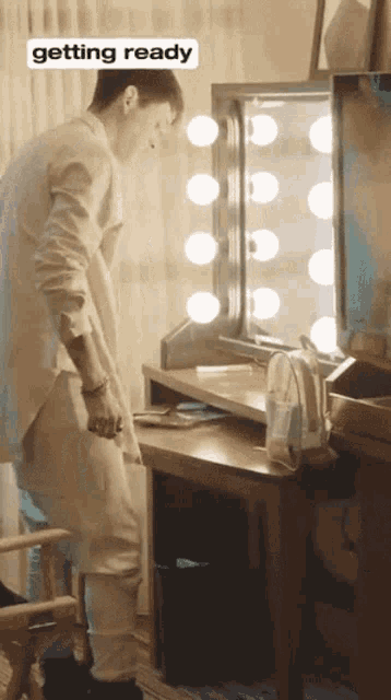 a man standing in front of a mirror with the word getting ready on the bottom