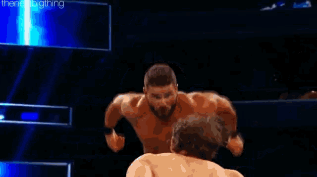 a wrestler is doing a flip in a wrestling ring