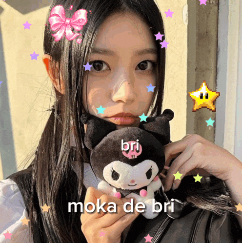 a girl is holding a stuffed animal with the name bri on it