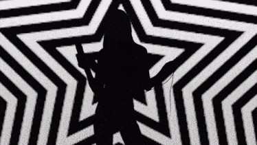 a silhouette of a woman holding a microphone in front of a black and white star pattern .