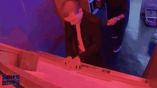a man in a suit is working on a piece of paper with spies disguise written on the bottom right