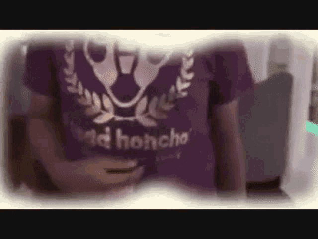 a person wearing a purple shirt with the word honcho on the front