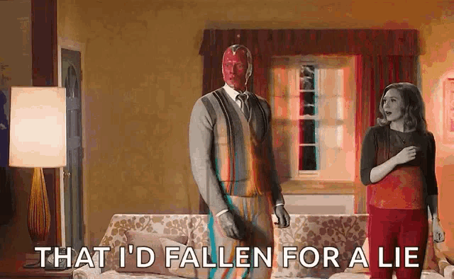 a man and a woman are standing next to each other in a living room and the man is wearing a red mask .