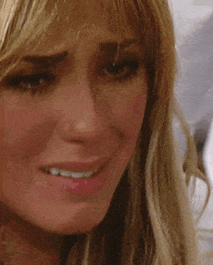 a close up of a woman 's face with a tear running down her cheek