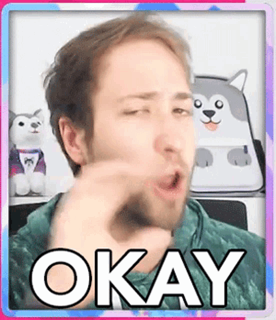 a man is making a funny face and the word okay is on the bottom of the picture .