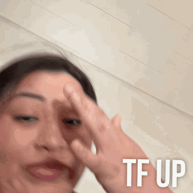 a blurry picture of a woman 's face with the words tf up on the bottom