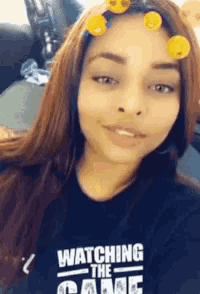a girl wearing a black shirt that says watching the game