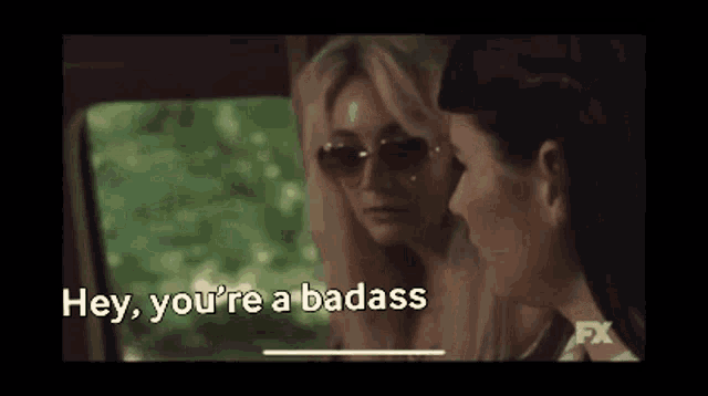 two women are sitting in a car and one of them says hey you 're a badass .