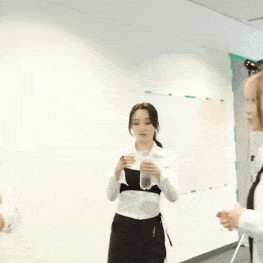 two women are standing next to each other and one of them is giving the other a high five .