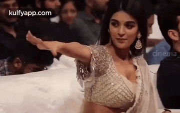 a woman in a white blouse is dancing in front of a crowd .