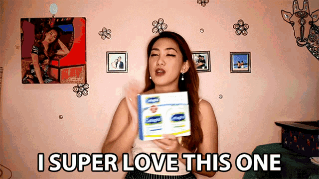 a woman is holding a box and saying i super love this one