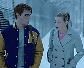 a man and a woman standing next to each other in the snow .