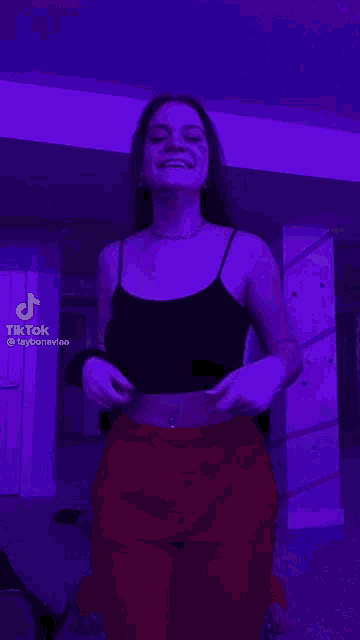 three women are standing next to each other in front of a purple light .