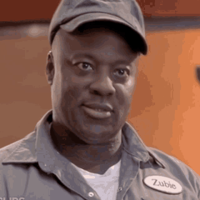 a man wearing a hat and a patch that says zubie
