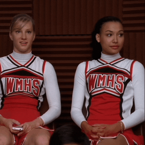 two wmhs cheerleaders sit next to each other