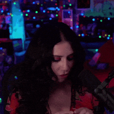 a woman with a cross tattoo on her wrist is holding a red heart