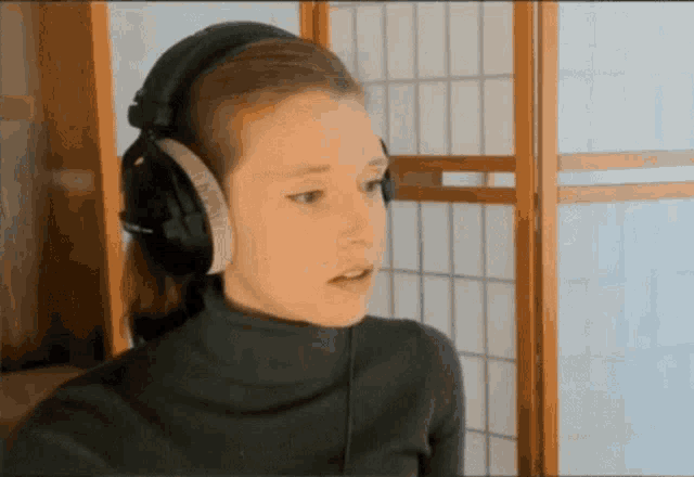 a woman wearing headphones and a black turtleneck sweater