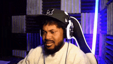 a man with a beard wearing headphones and a hat with the letter j on it