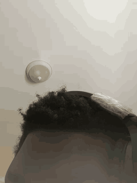 a person 's head is visible in front of a white ceiling