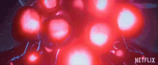 a bunch of red balloons are floating in the air on a dark background .
