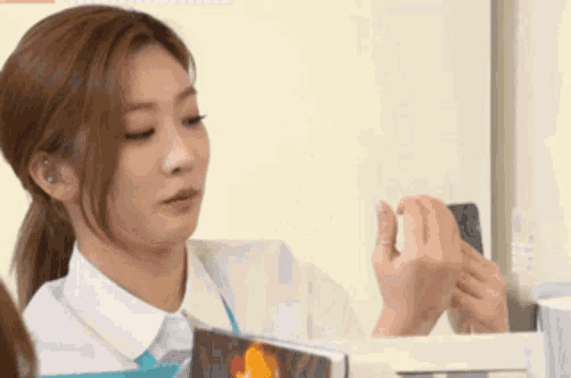 a woman in a white shirt is taking a picture of herself with a cell phone .