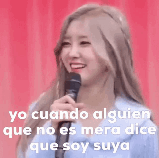 a woman is smiling while holding a microphone and the words yo cuando alguien que no es mera dice que soy suya