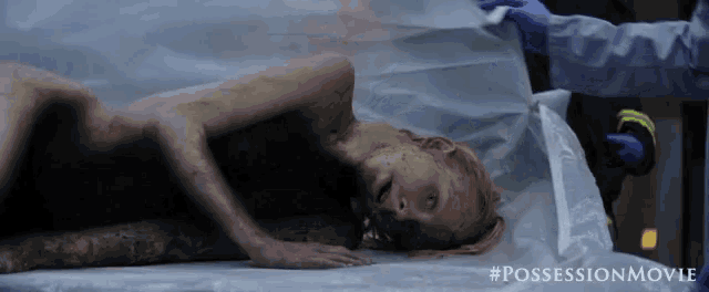 a woman is laying on a stretcher in a morgue .