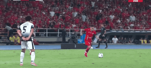 a soccer player with the number 5 on his jersey is kicking the ball