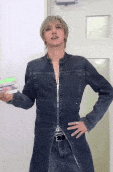 a man in a denim jacket is holding a green container