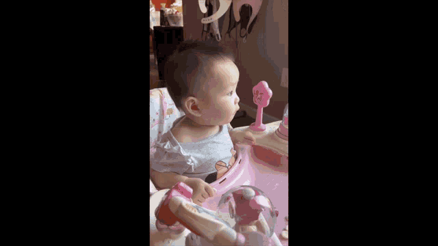 a baby in a minnie mouse shirt is sitting in a high chair