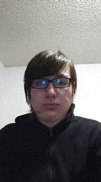 a man wearing glasses and a black jacket is looking at the camera