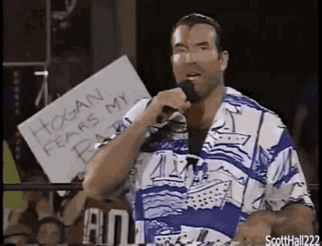 a man is holding a microphone and holding a sign that says hogan fears my beard .