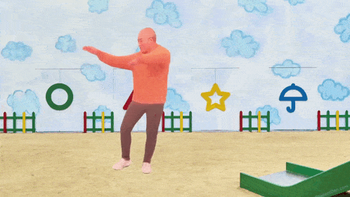 a man in an orange hoodie stands with his arms outstretched in front of a wall with drawings of clouds and a star