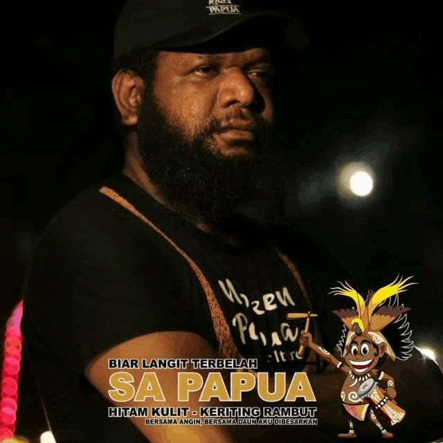 a man with a beard wearing a black shirt that says sa papua