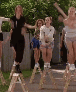 a group of women are sitting on wooden ladder 's and jumping in the air .