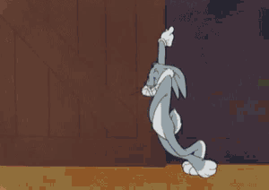 a cartoon character named bugs bunny is peeking out from behind a wall