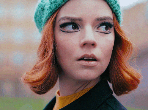 a close up of a woman 's face wearing a green hat