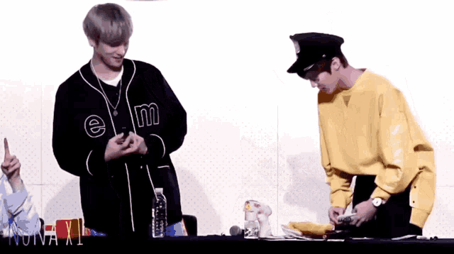 a man wearing a yellow sweatshirt with the letter m on the front